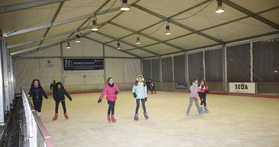 Varias niñas patinan por la pista de hielo del Salón. 