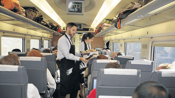 Dos camareros reparten queso de Palencia en un tren Ave.