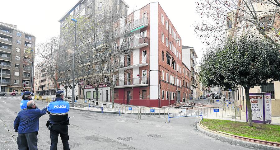 Dos policías locales vigilan la zona y observan el estado del edificio ante la presencia de un vecino. 