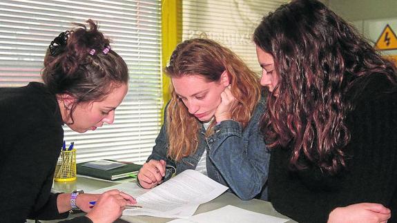 Dos jóvenes firman un contrato en una empresa de trabajo temporal. 