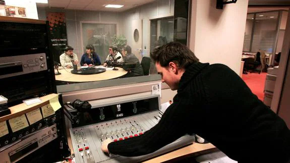 Un técnico de sonido supervisa la grabación de un programa de radio en el estudio de una emisora.