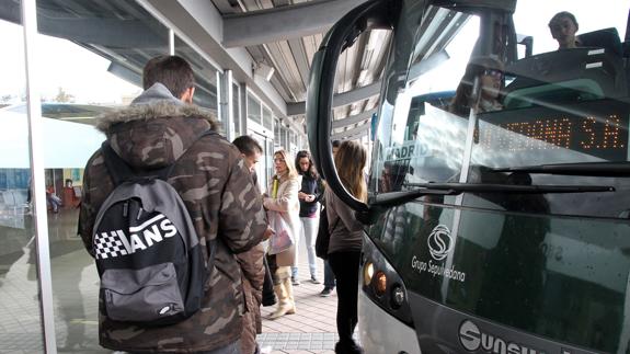 Usuarios del servicio de transporte por carretera a Madrid se suben a un autobús Segovia-Madrid. Tanarro