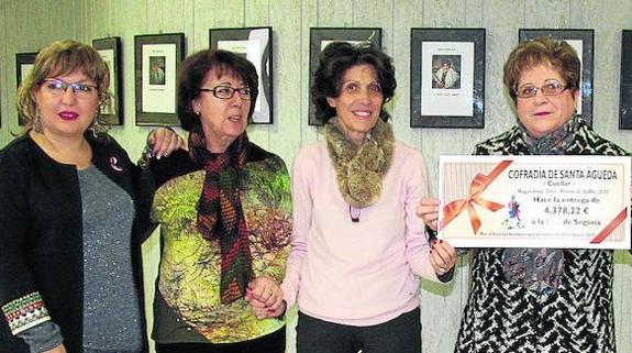 La mayordoma muestra el cheque antes de entregárselo a la presidenta de la AECC, Ana Sanjosé (a su derecha). 