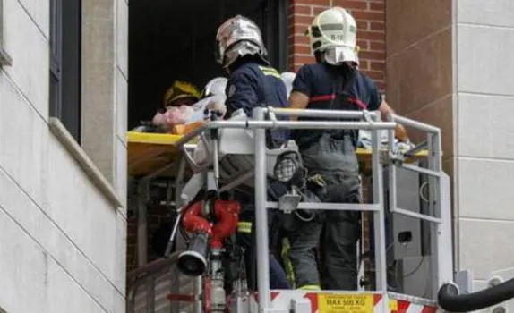 Los bomberos de Bilbao sacan a la mujer por la ventaja de su casa.