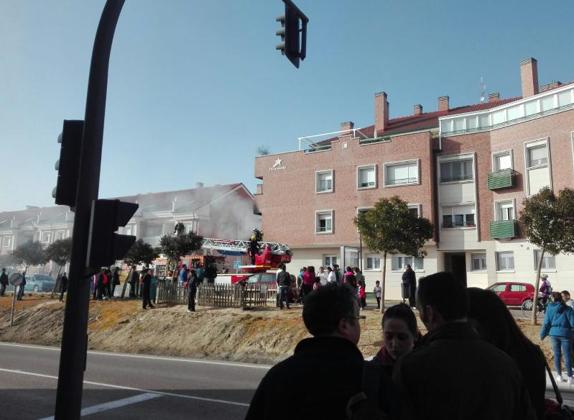 Los vecinos de la zona contemplan la labor de los bomberos junto al piso incendiado en Zaratán.