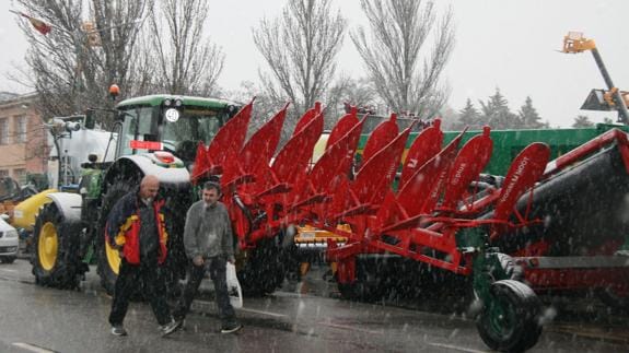 La nieve cae sobre la maquinaria agrícola expuesta para la feria. M. Rico
