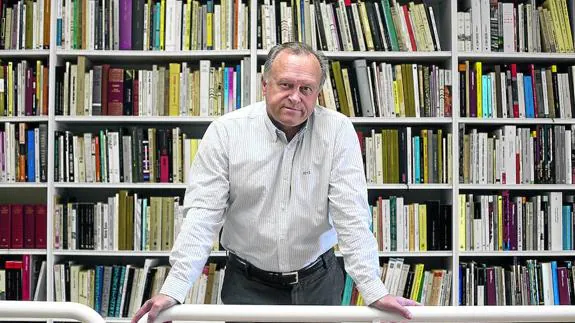 Miguel Pardeza posa delante de una pequeña parte de los libros que atesora