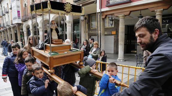 Un grupo de niños aprende a cargar un paso.
