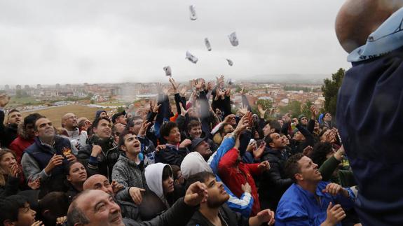 Vecinos y seguidores de la pedrea del pan y el quesillo tratan de atrapra una de las bolsas lanzadas. ANTONIO QUINTERO