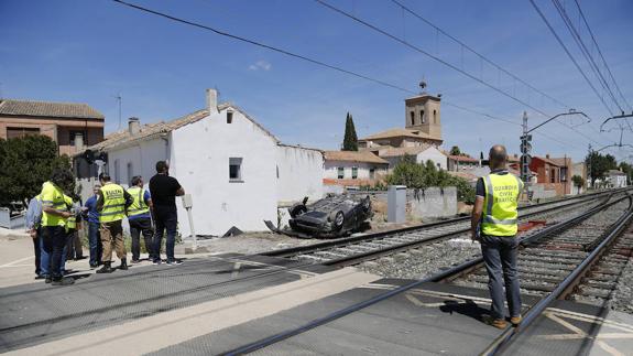 Guardias civiles y empleados de Adif trabajan en la zona. En el centro de la imagen, el coche siniestrado. 