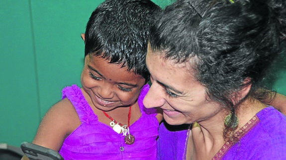 Chandana, la alumna nás pequeña que han adaptado, con Gema García, mirando el teléfono.