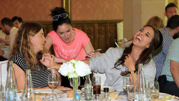 Paula Echevarría ríe a carcajadas, junto a dos miembros del equipo, durante el receso del rodaje para la comida. 