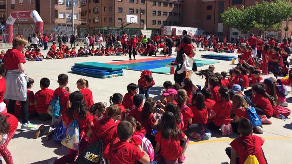 Un grupo de escolares viendo y participando en la jornada deportiva.