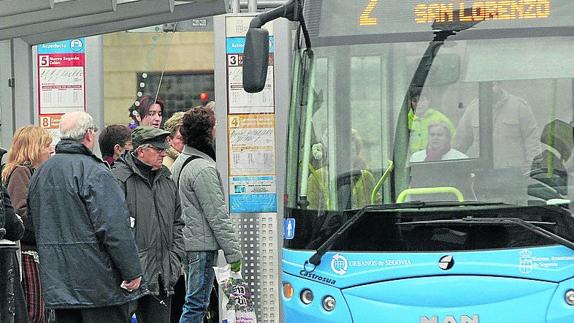 Viajeros esperan un autobús urbano en Segovia. 