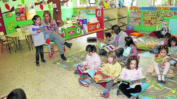 Los niños de Infantil, con la profesora Asun Vegara, en la ‘pequebiblioteca’.