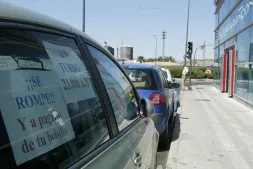 Pancartas de protesta en un coche aparcado delante de un concesionario./ A. FARIZA