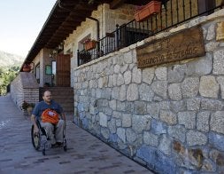Una persona en silla de ruedas, junto a la casa rural. / R. HERNÁNDEZ