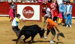 A la izquierda, los jóvenes se divierten durante la probadilla en la suelta de vaquillas. A la derecha, los pequeños trepan por una de las atracciones. / M. RICO
