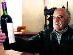 José Hernán mira su botella de Vega Sicilia. / GABRIEL VILLAMIL
