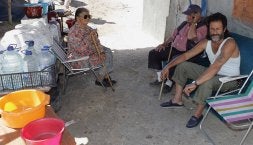 De izquierda a derecha, Adoración Romero, Antonio Barrul 'el Abuelo' y el hijo mayor de la pareja, Francisco. En            primer término, baldes y garrafas con los que sofocaron las llamas./ H. S.