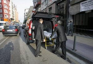 Los operarios de la funeraria trasladan el cuerpo de la víctima. / L. PALOMEQUE