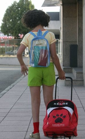 La niña, con sus mochilas para ir al colegio./ RAMÓN GÓMEZ