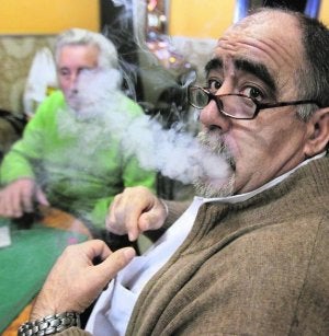 Un fumador expulsa el humo del puro mientras echa la partida en un un bar. ::
GABRIEL VILLAMIL