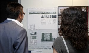 Dos visitantes de la exposición observan el trabajo ganador en la categoría de vivienda colectiva. ::
A. Q