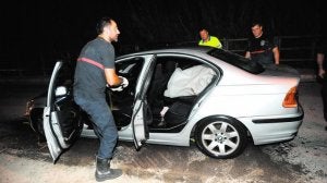 Bomberos revisan el coche donde estuvo encerrada la mujer. ::
ALFONSO DURÁN /
AGM