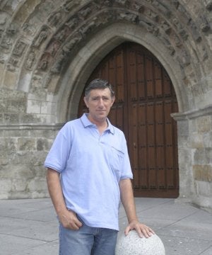 Jesús Torrellas posa ante la entrada principal de la palentina iglesia de San Miguel. :: VÍCTOR HERRERO