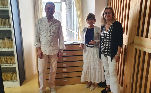 Imagen principal - Arriba, Laura Regueira Vera (en el centro), junto a la directora de la BIEX, Julia Inés Pérez, y el técnico Javier Paule. Abajo, detalle del carné de periodista de Francisco Vera, y otros documentos del escritor alconchelero.