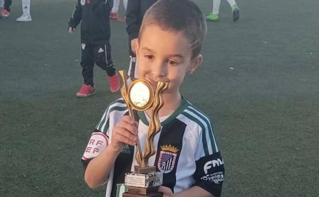Imagen principal - Arriba, Thiago Torrescusa, celebrando su primer trofeo con el C.D. Badajoz; abajo, a la izquierda, junto a su amigo Francisco Javier Periáñez, animando desde las gradas al C.F. Alconchel; a la derecha, junto a su padre, Enmanuel Torrescusa, y su tío Manuel Piñana, tras el primer entrenamiento en Badajoz, el pasado mes de septiembre. 