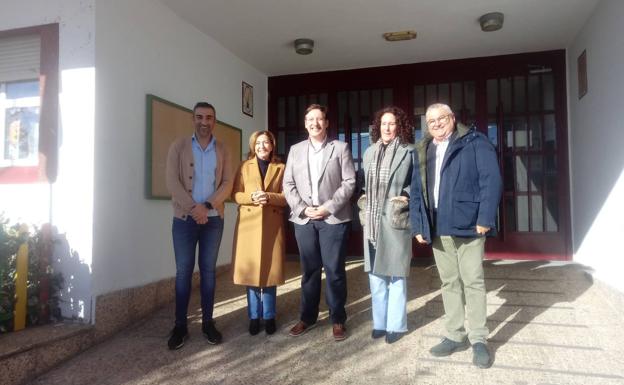 Imagen principal - Arriba, el secretario general, flanqueado por el alcalde y miembros del equipo directivo del colegio de Alconchel; abajo, visitando las nuevas instalaciones para hacer deporte a cubierto y la biblioteca escolar.