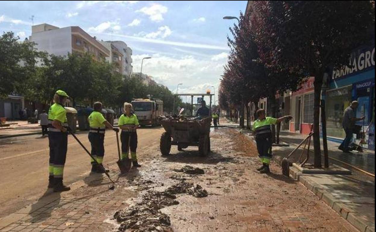 Operarios municipales se afanan hoy por limpiar el barro de las calles. 