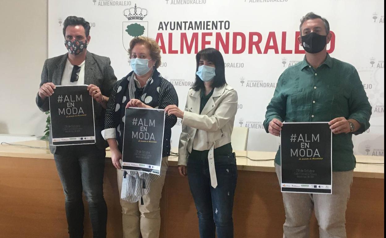 El responsable del desfile muestra el cartel con los presidentes de Asemce y Ceal y la concejala. 