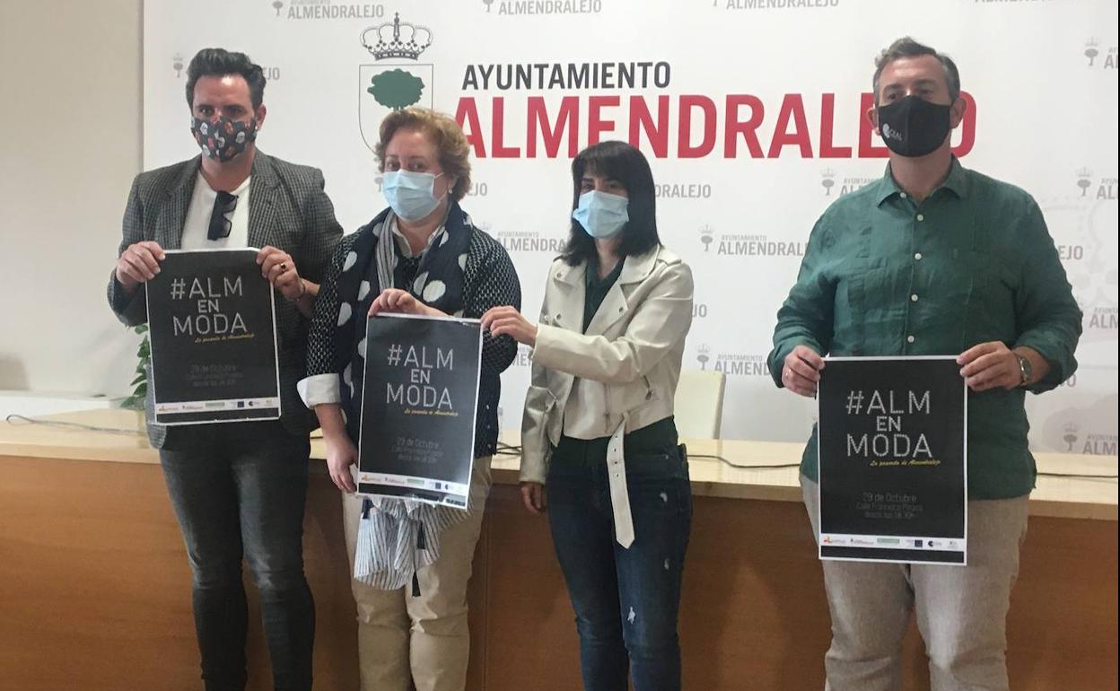 Organizadores y la concejala muestran el cartel del desfile ahora suspendido. 
