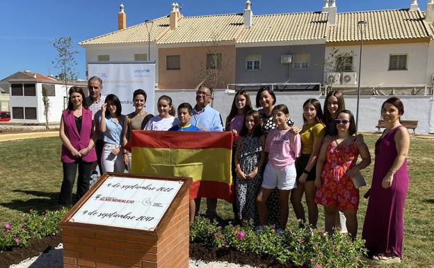 Niños, concejales y el alcalde posan frente a la cápsula del tiempo en el parque. 