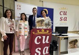 La investigadora y las profesoras muestran el cartel junto al representante de Cajalmendralejo.