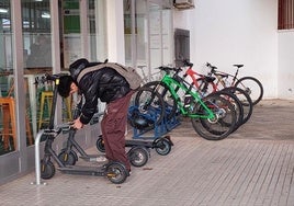 Un alumno deja su patinete a las puertas del centro antes de entrar en clase