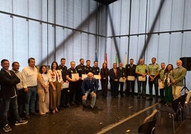 Algunos de los galardonados posan con representantes políticos a la conclusión del acto