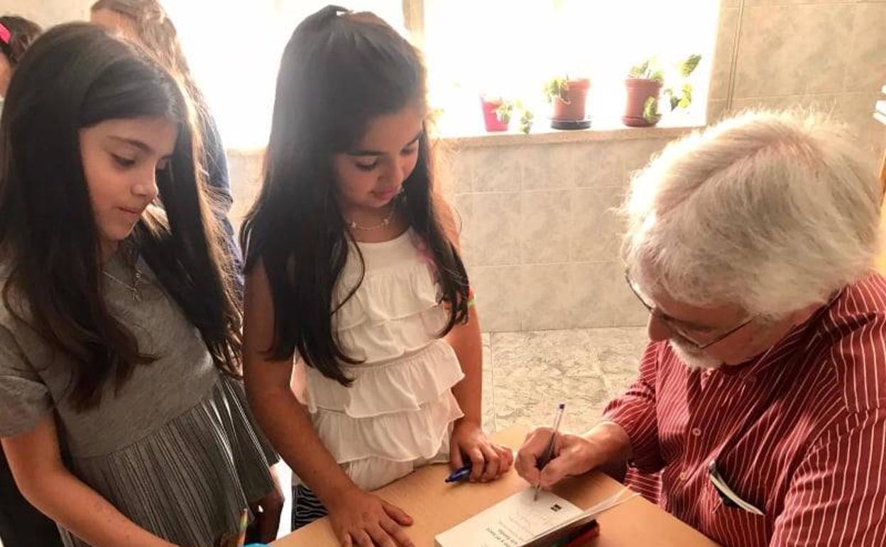 Alfredo Gómez Cerda firmando autógrafos para los niños.