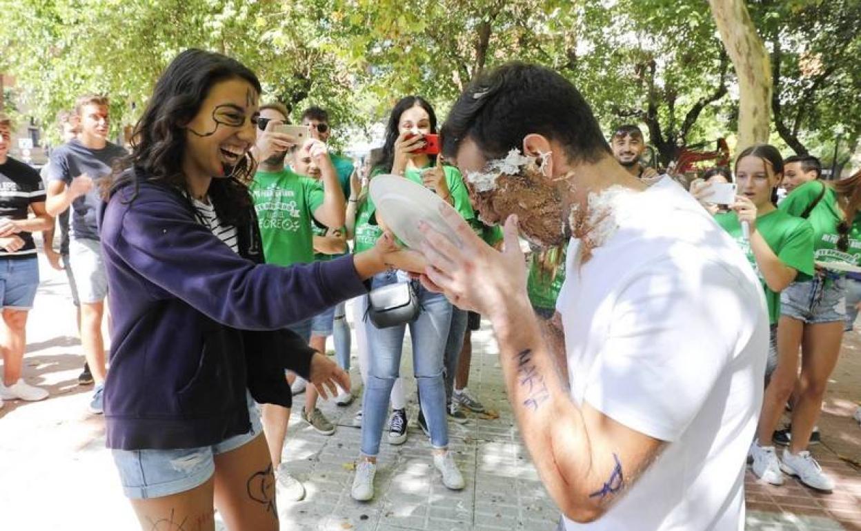 Un estudiante recibe un 'tartazo' en la cara de manos de una compañera, ayer en Cánovas.
