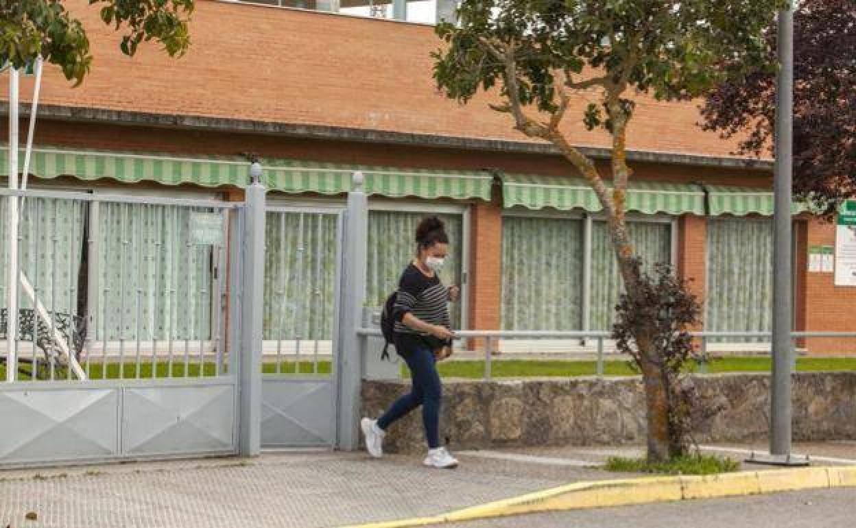Una mujer con mascarilla sale de la residencia de mayores Virgen de la Luz de Arroyo de la Luz. 