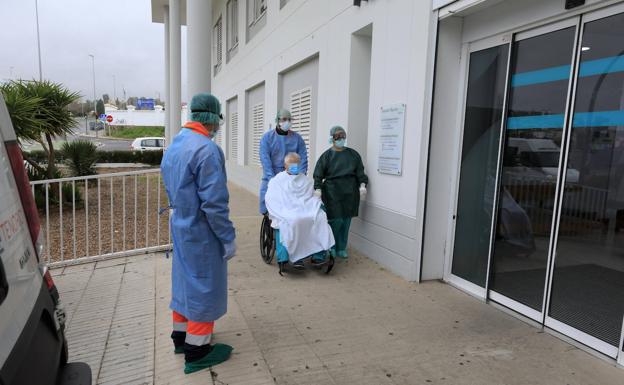 Tres profesionales sanitarios trasladando a un enfermo.