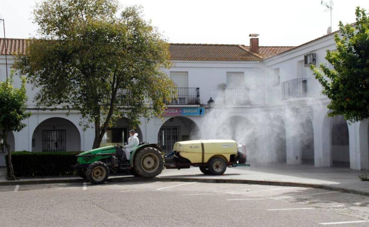 Un agricultor colaborando con su tractor en las labores de desinfección. 