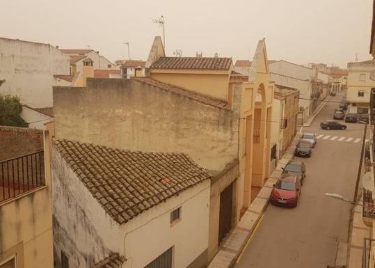 Imagen principal - La calima tiñe de naranja Arroyo de la Luz