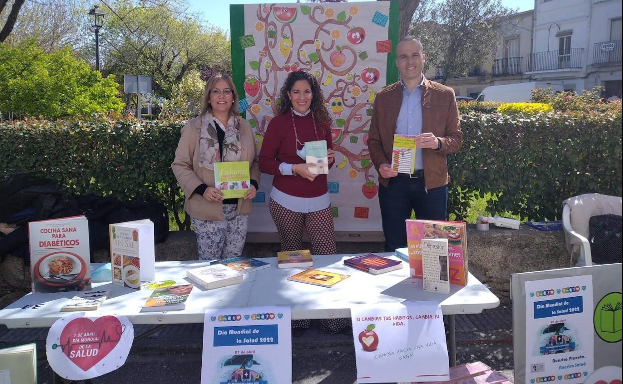 de izquierda a derecha: la concejala Mercedes Pérez, la responsable de la biblioteca Esther Cordero y el alcalde arroyano Carlos Caro, en la Feria de la Salud. 