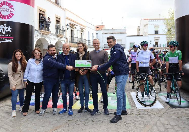 Imagen principal - Arriba, las autoridades en la salida de la carrera. Debajo, el pelotón por las calles de Arroyo de la Luz.