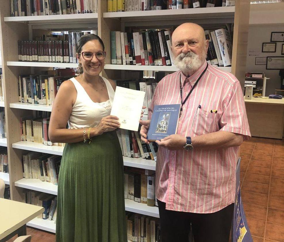Esther Cordero, responsable de la biblioteca arroyana, recogiendo el libro de manos de su autor.