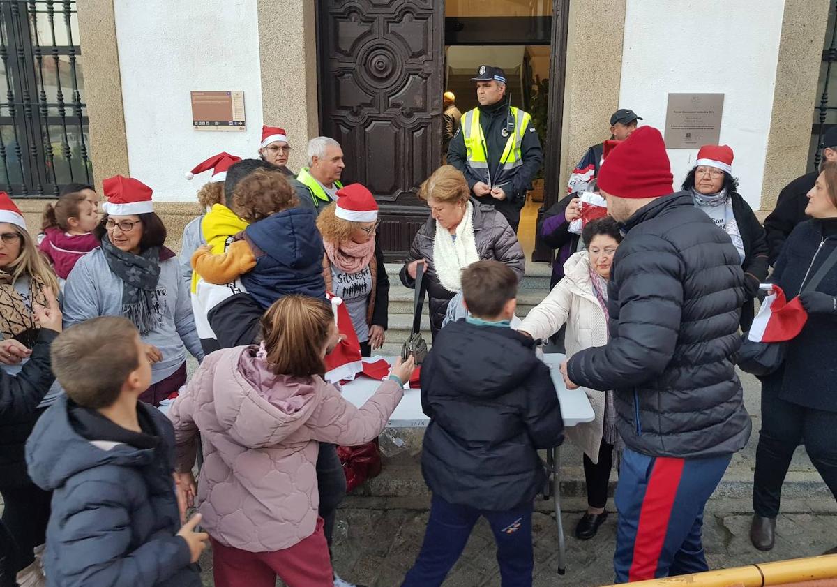 Imagen principal - Antes del inicio de la carrera se repartieron gorros de Papá Noel entre los participantes.
